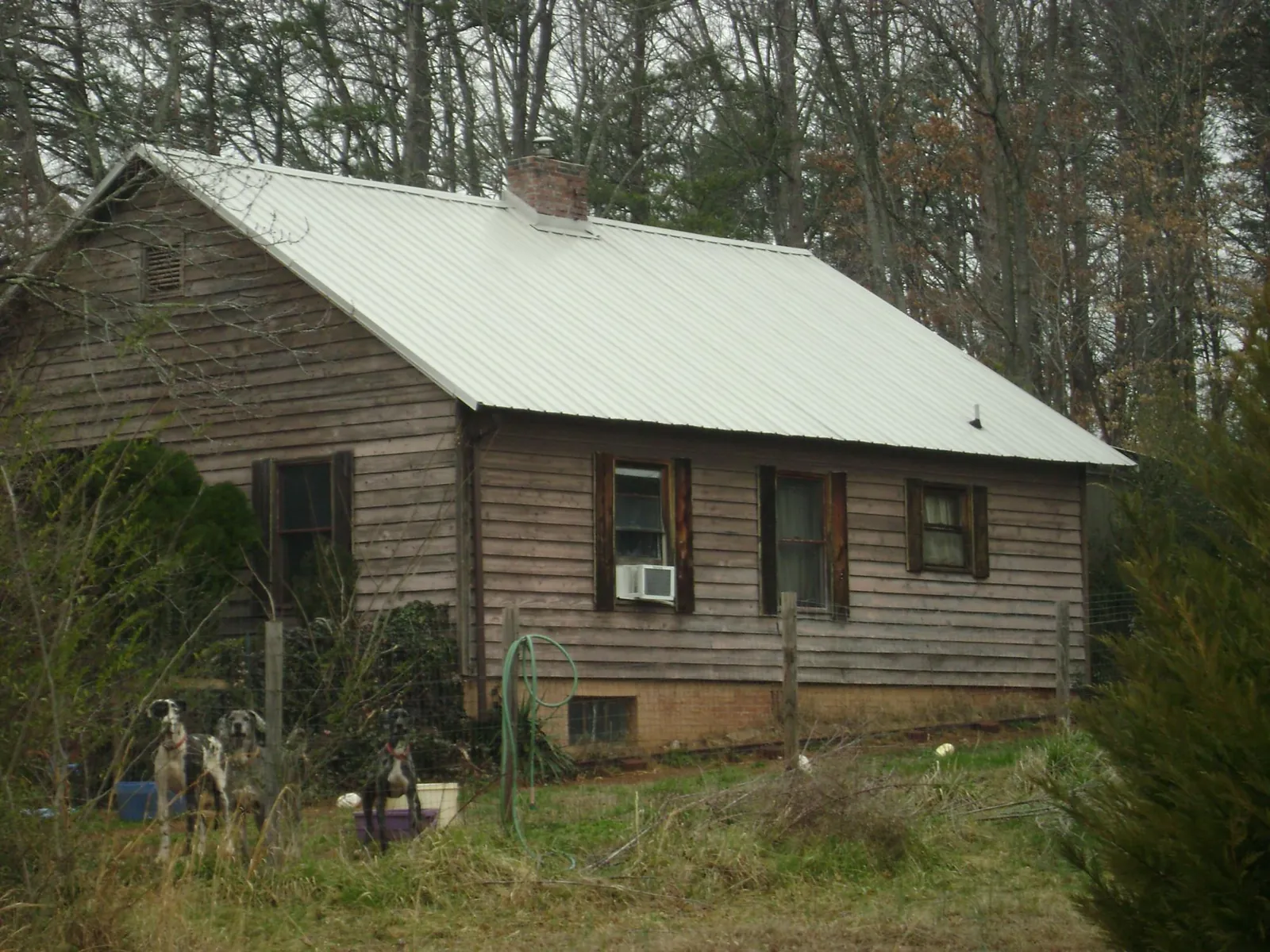 White metal roof on an old wood sided farmhouse, from a Metal Roof Installation job in Republic